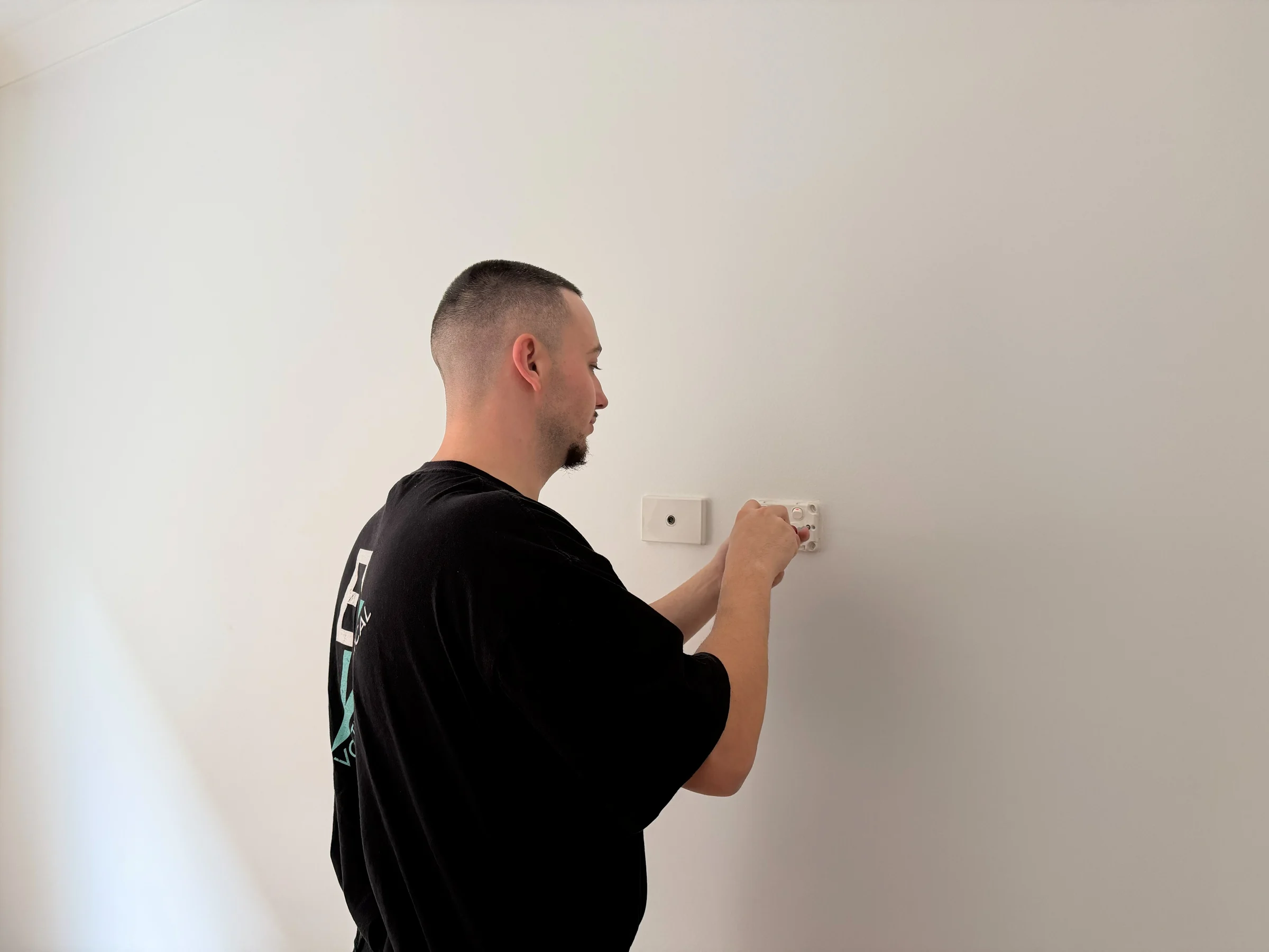 Voltra electrician fitting a wall switch