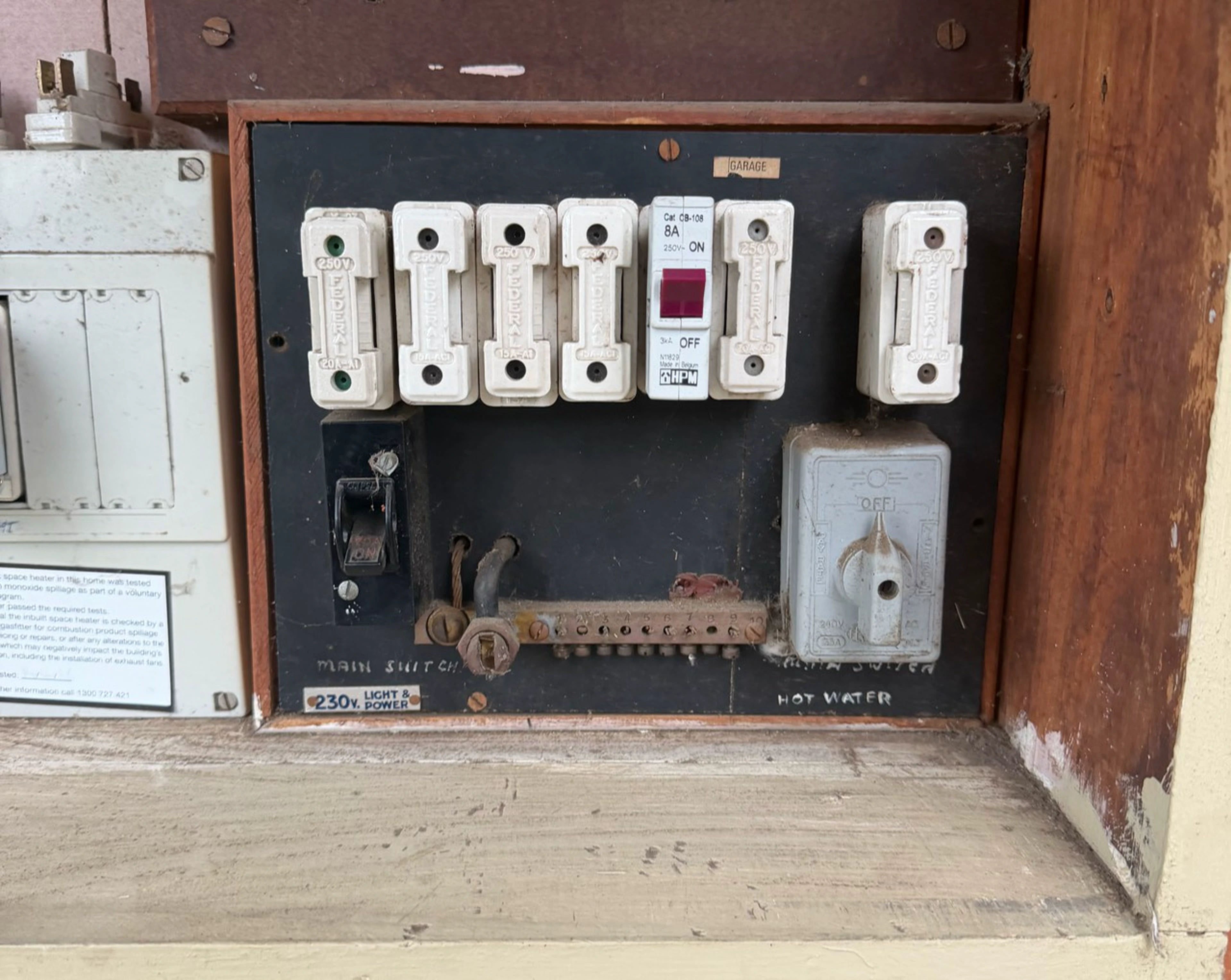 Before the Voltra upgrade: the original ceramic fuses in the timber switchboard cabinet